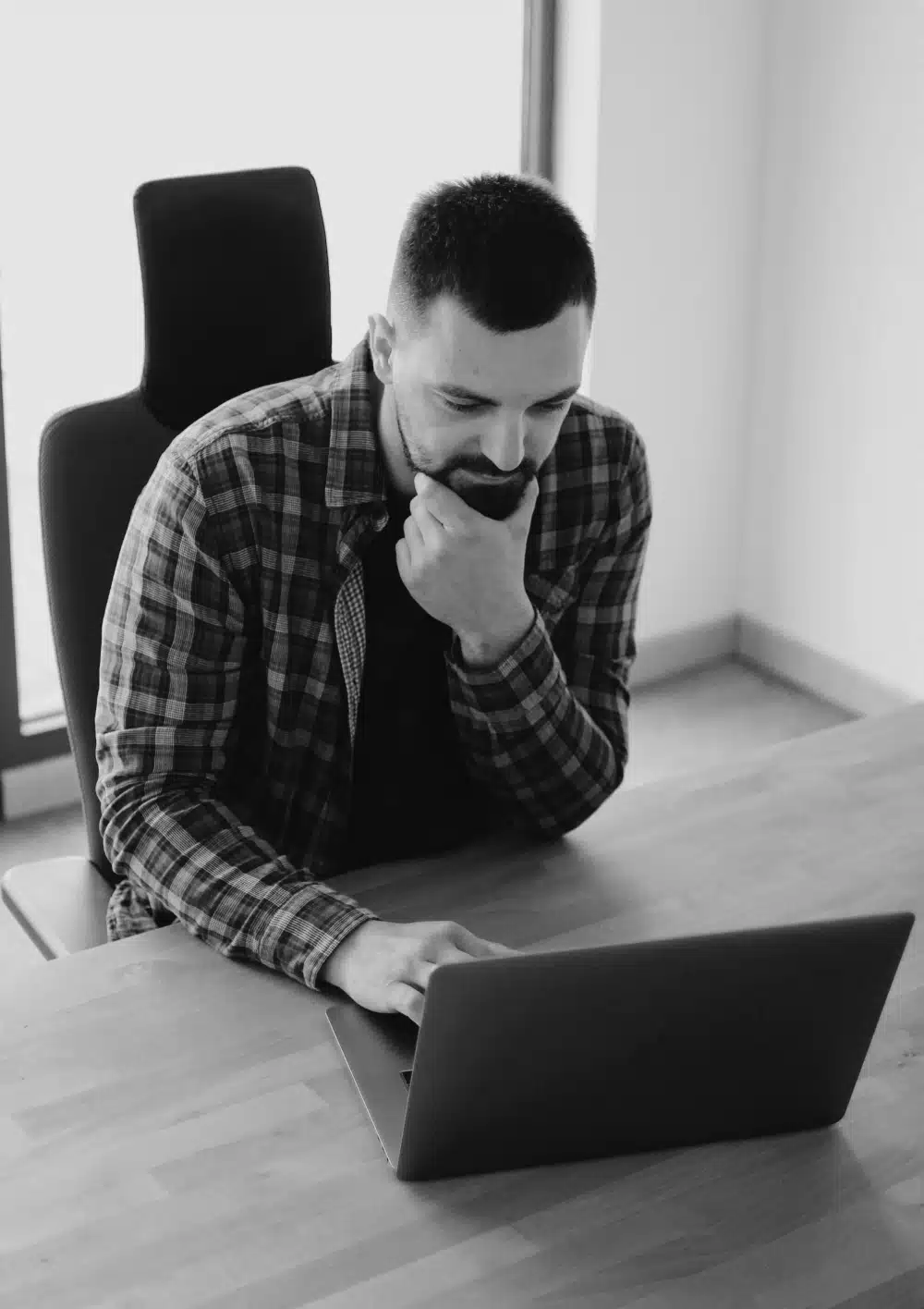A bearded man working at a laptop